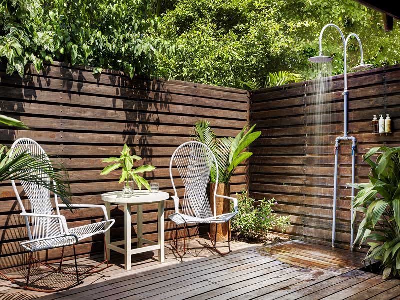 A wooden deck with two chairs and a table.